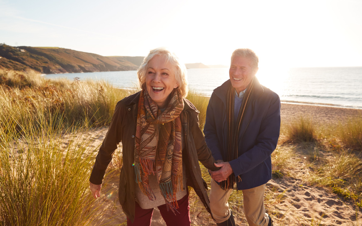 Woman walking with man on sand dunes 